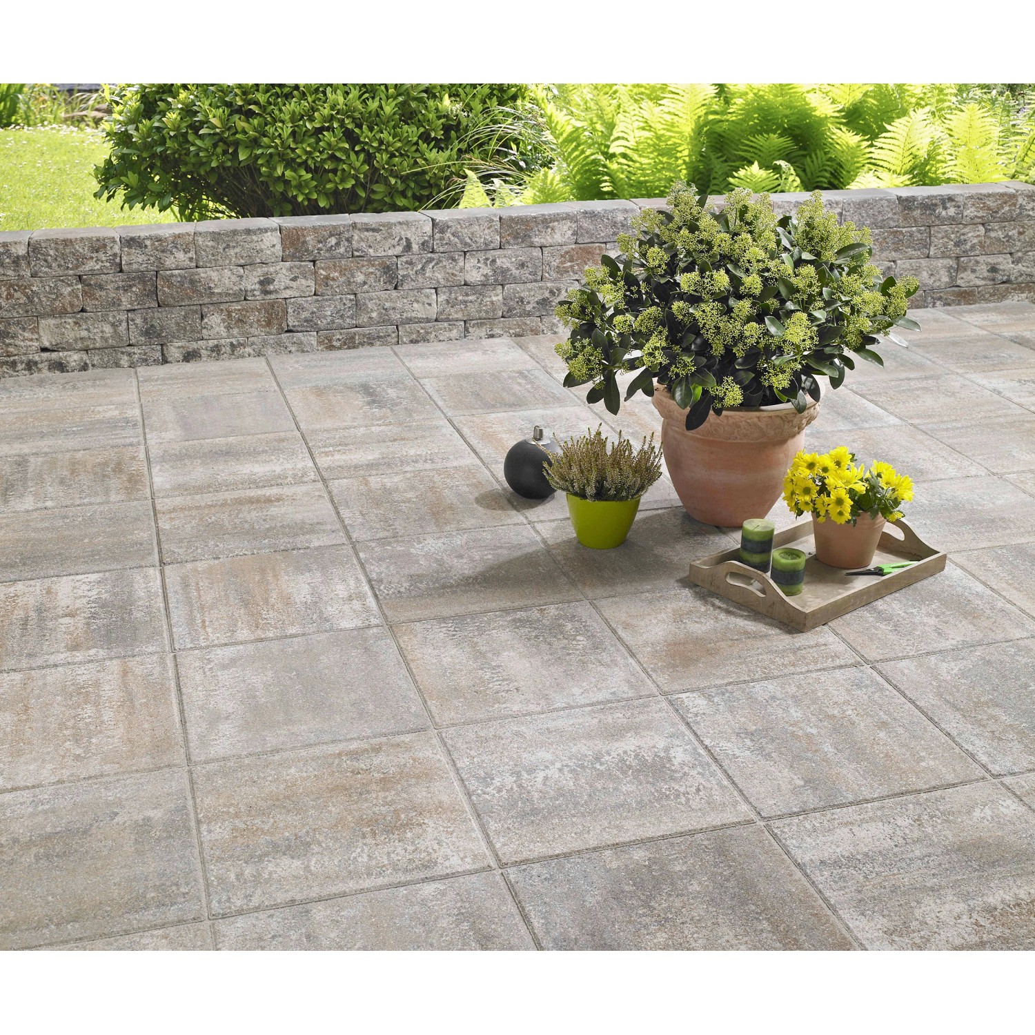 Terrassenplatten Bologna Jura-Nuanciert 40x40 cm auf Terrasse mit Pflanzen.