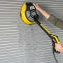 Kärcher Flächenreiniger T 7 Plus T-Racer im Einsatz an einer Garagenwand. Der gelbe Flächenreiniger wird mit der Hand geführt.