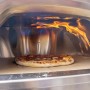 Buschbeck Pizzaofen X1 mit Pizza im Ofen unter Flammen.
