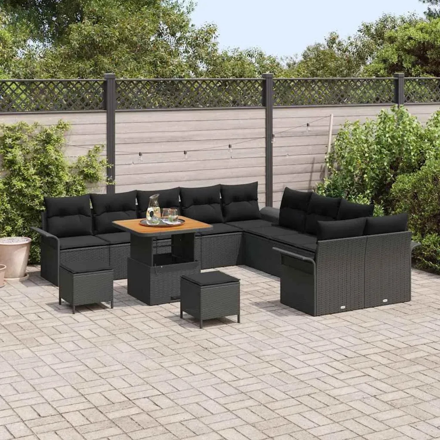 Schwarzes 13-teiliges Garten-Sofa-Set aus Poly Rattan mit Tisch und Hockern für den Außenbereich.