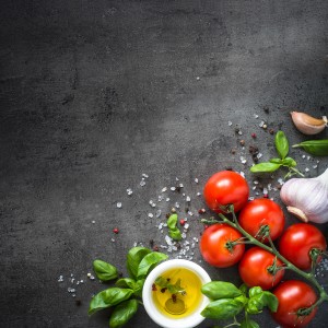 Memo-Art Memoboard Ingredients: Tomaten, Knoblauch, Basilikum und Öl auf dunklem Hintergrund.