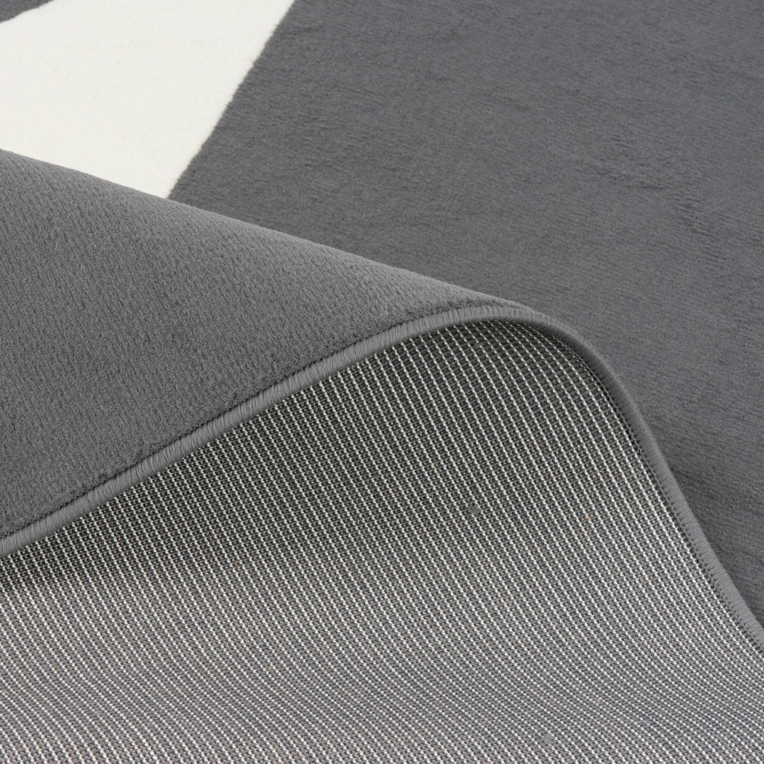 Nahaufnahme: Anthrazitfarbener Kinderteppich mit Sternmuster, 185x270cm. Kurzflorteppich, Parkett schonend.