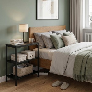Schwarzer Relaxdays Nachttisch aus Holzwerkstoff und Stahl mit 3 Ablagen, mit Lampe und Büchern, neben Bett.