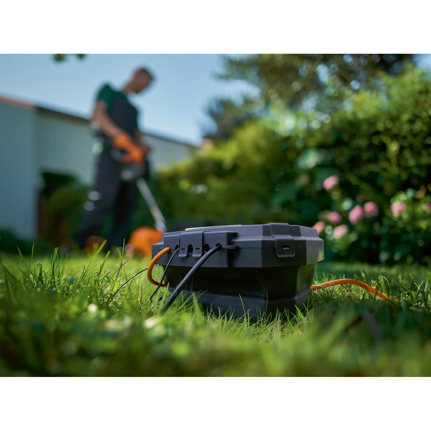 D-Line Wetterschutzbox, faltbar, mit 3 Steckdosen und Kabel im Garten.