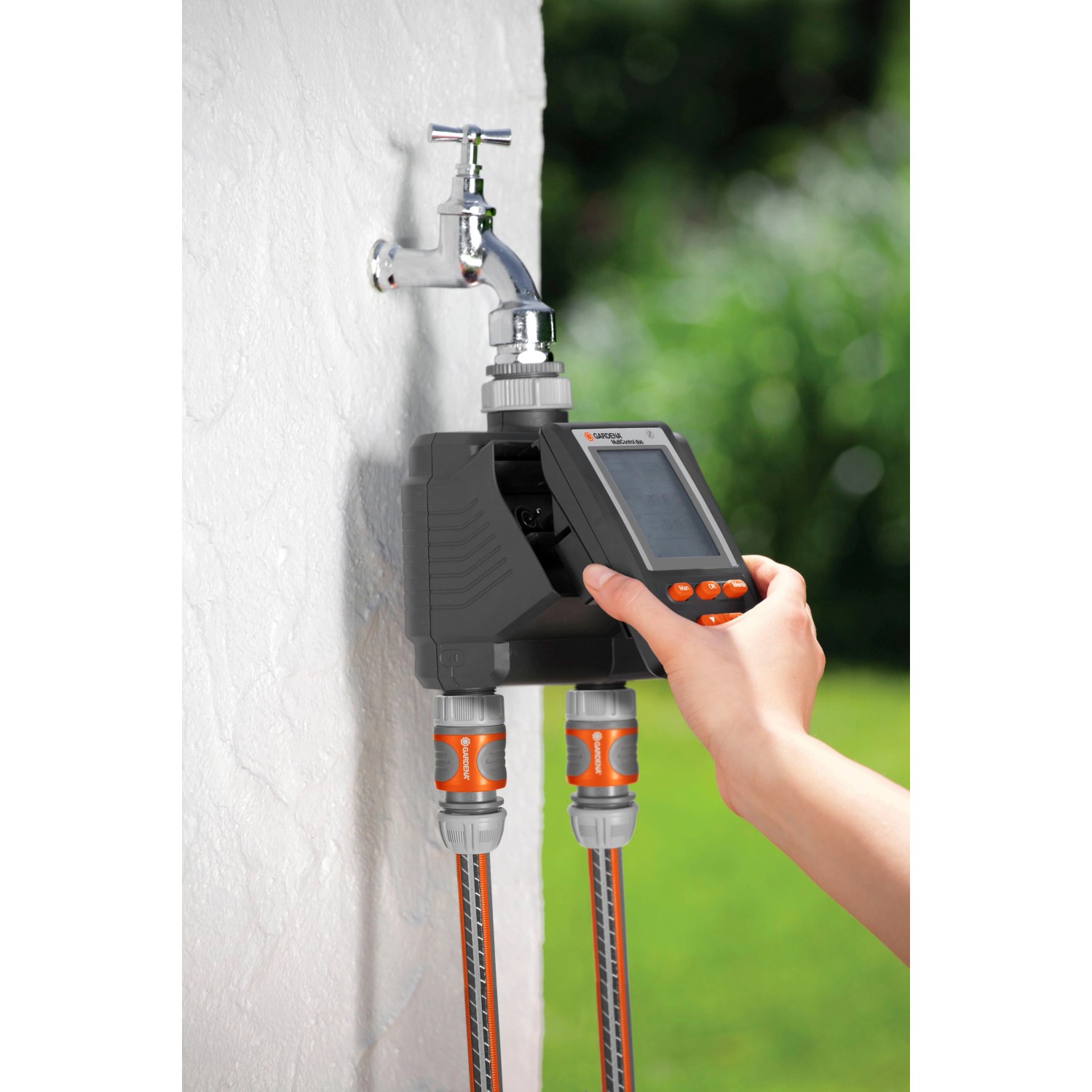 Gardena MultiControl duo Bewässerungscomputer am Wasserhahn mit zwei angeschlossenen Schläuchen.