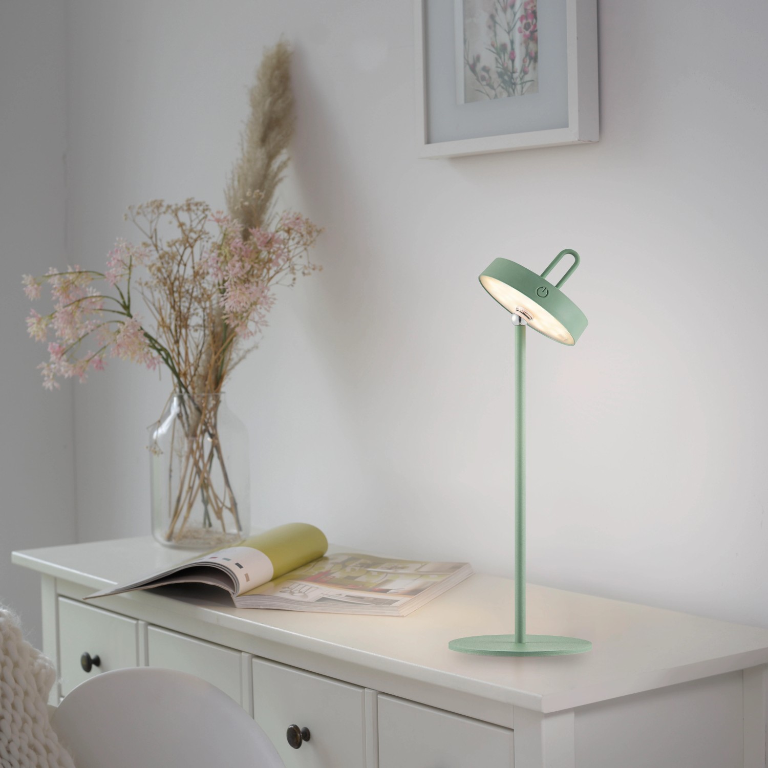 Grüne LED-Akku-Tischleuchte Amag von Just Light, 47,2 cm hoch, auf weißer Kommode.