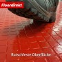 Roter PVC-Bodenbelag mit Quadra-Muster und rutschfester Oberfläche, Schuh im Bild.