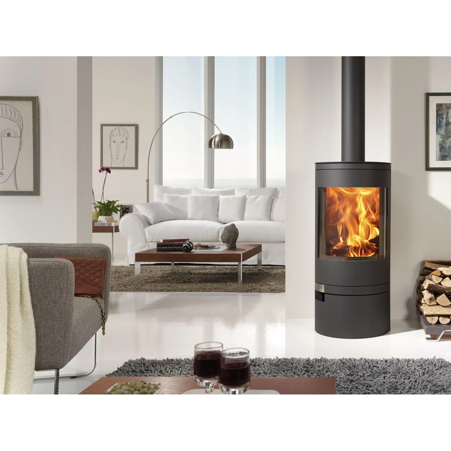 Panadero Ecodesign Kaminofen in Schwarz-Metallic mit brennendem Feuer im Wohnraum.