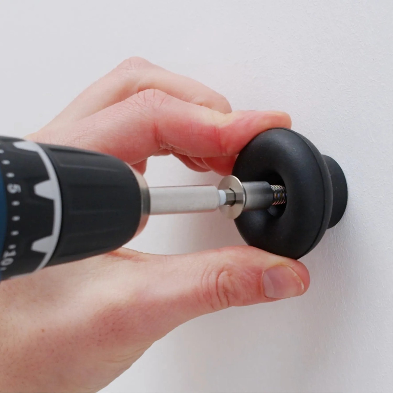Montage des hellgrauen Wagner Wandhakens Hooks4home Dot mit Schraubenzieher.