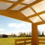 Skan Holz Gartenhaus Holmestrand Natur, 380x300 cm, mit offenem Dach und Blick in die Natur.
