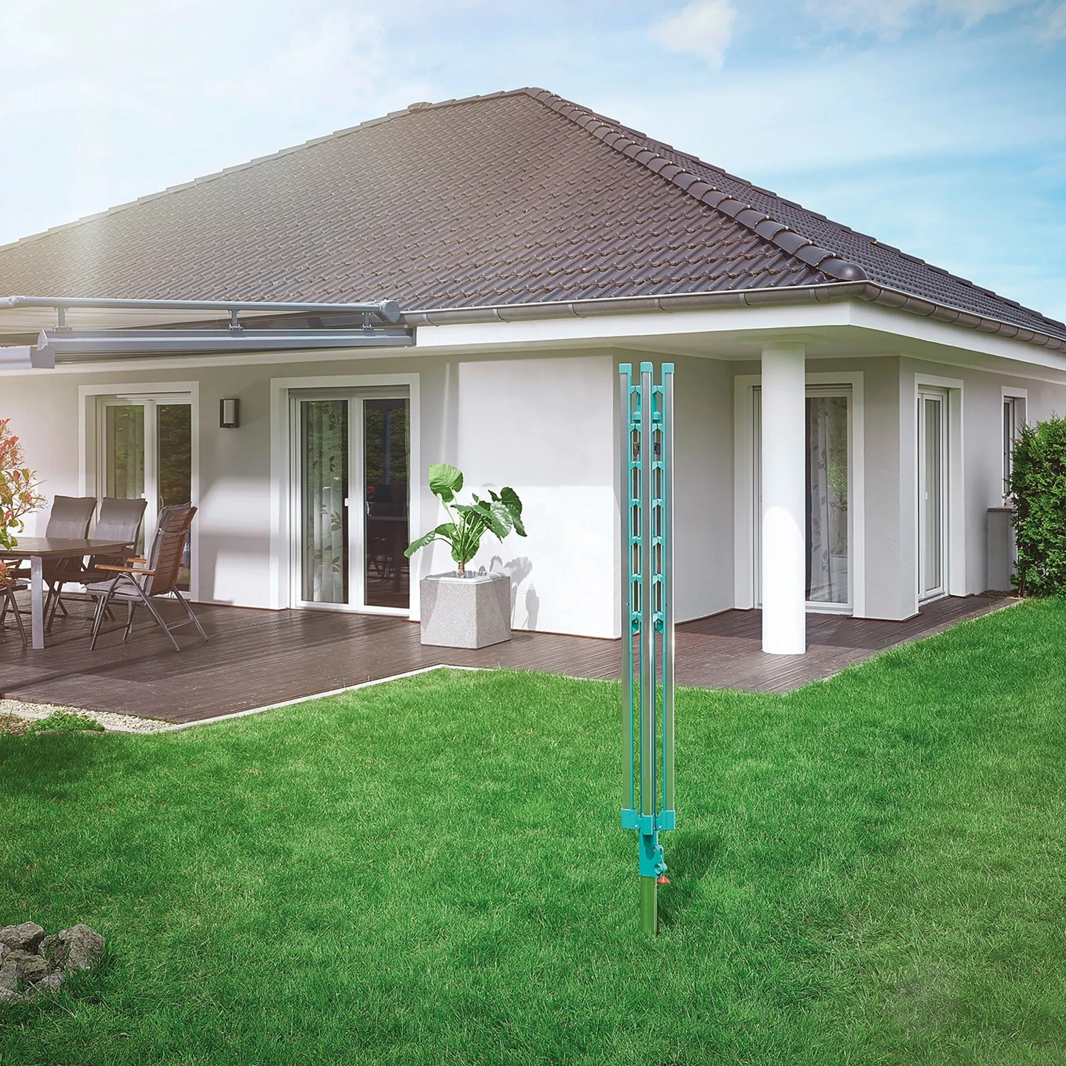 Zusammengeklappte Leifheit Wäschespinne Linomatic 400 Easy im Garten vor einem Haus.
