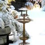 Bronze Solar Vogelbad 4-in-1 aus Metall im Schnee mit Vögeln. Multifunktionale Vogeltränke & Futterstelle für den Garten.