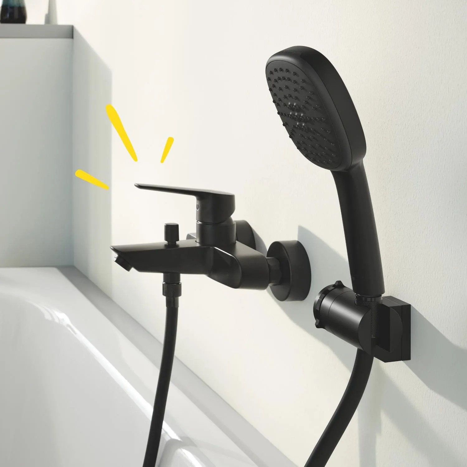 Grohe QuickFix Wannenarmatur Start, schwarz, mit Handbrause an der Badewanne.