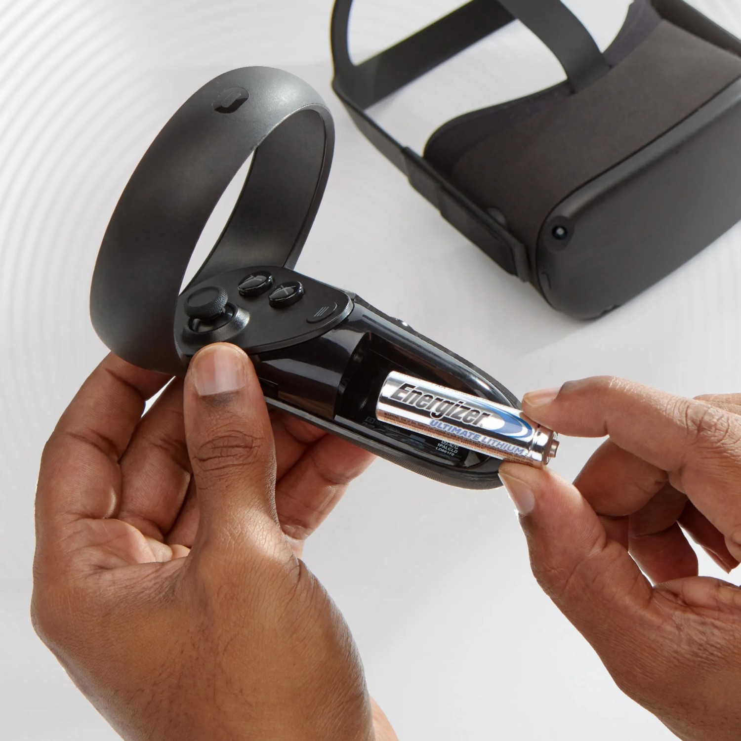 Energizer Lithium AA Batterie wird in einen Controller eingesetzt. VR Brille im Hintergrund.