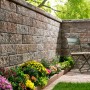 Kann Bruchsteinmauer Jura-Nuanciert, Grundelement 50x25x15 cm. Gartenmauer mit Blumen und Sitzplatz.