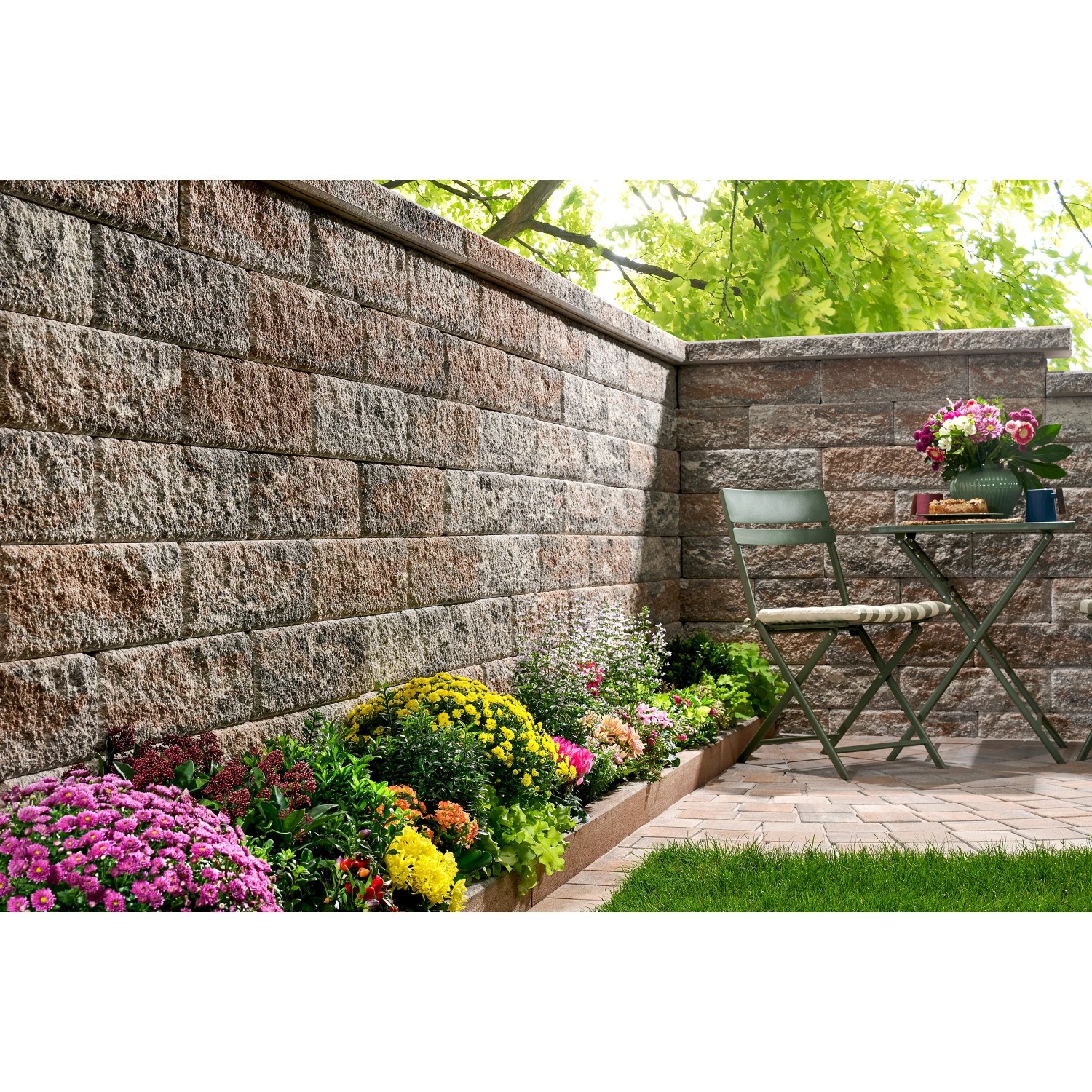 Kann Bruchsteinmauer Jura-Nuanciert, Grundelement 50x25x15 cm. Gartenmauer mit Blumen und Sitzplatz.