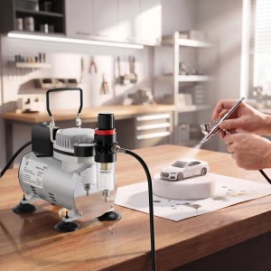 Wiltec Airbrush Kompressor AF18-2 auf Holztisch, sprüht mit Airbrush-Pistole Farbe auf weißes Modellauto. Mit Manometer & Wasserfilter.