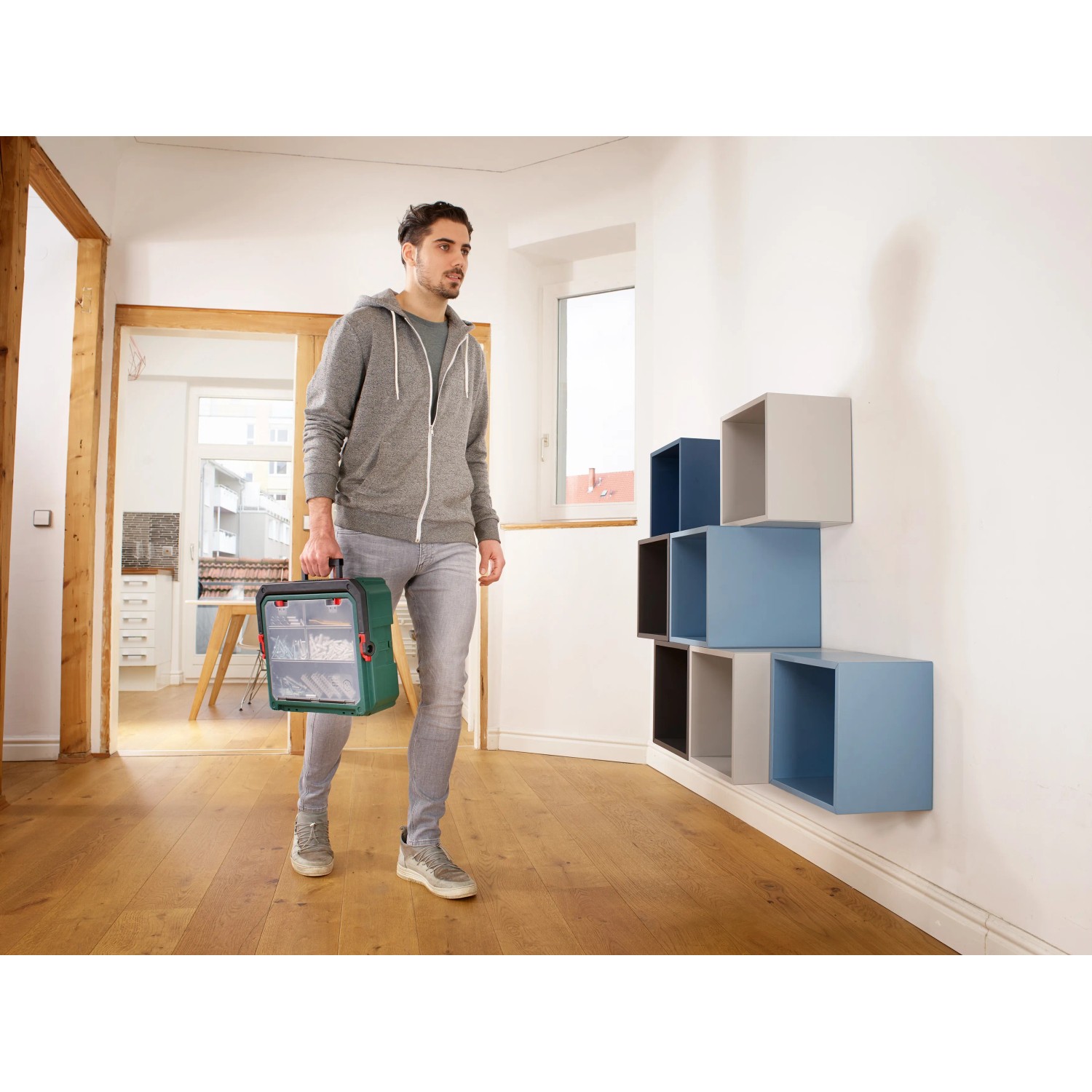 Mann trägt grüne Bosch Deckelbox für Systembox S. Aufbewahrungssystem für Werkzeug.