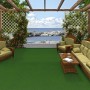 Grüner Snapstyle Kunstrasen Kingston 200x150cm auf Terrasse mit Gartenmöbeln und Meerblick.