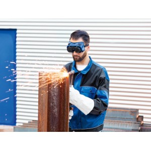 Mann trägt LUX-TOOLS Schweißer-Schutzbrille Schutzstufe 5 beim Brennschneiden von Metall. Funken fliegen. Augenschutz.