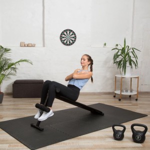 Relaxdays Bodenschutzmatten aus EVA-Schaum, schwarz, stoßdämpfend. Frau trainiert auf Fitnessmatte, ideal für Sportgeräte.