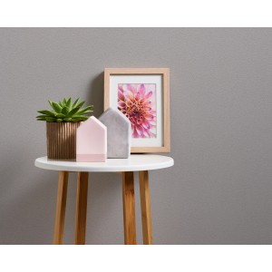 Nahaufnahme der silbernen Vliestapete Diamonds an der Wand, kombiniert mit Deko auf einem Tisch.