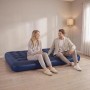 Dunkelblaue aufblasbare Luftmatratze für 2 Personen, auf der ein Paar bequem sitzt. Ideal für Camping & Outdoor.