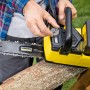 Kärcher Akku-Kettensäge CNS 18-30: Gelbe Akku-Kettensäge beim Spannen der Kette auf einem Holzstamm.