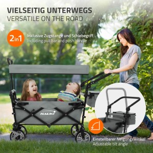 Grauer Hauki Bollerwagen XXL mit Dach, zwei Kinder sitzen darin, eine Frau schiebt ihn.