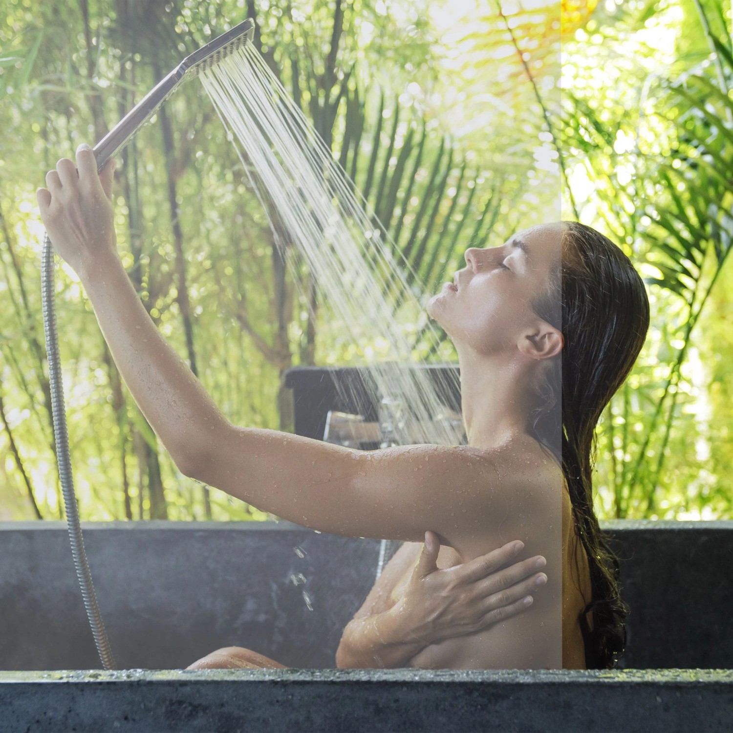 Frau duscht hinter transparentem Duschrollo aus PVC/Aluminium. Wasserabweisender Spritzschutz für Dusche und Badewanne.