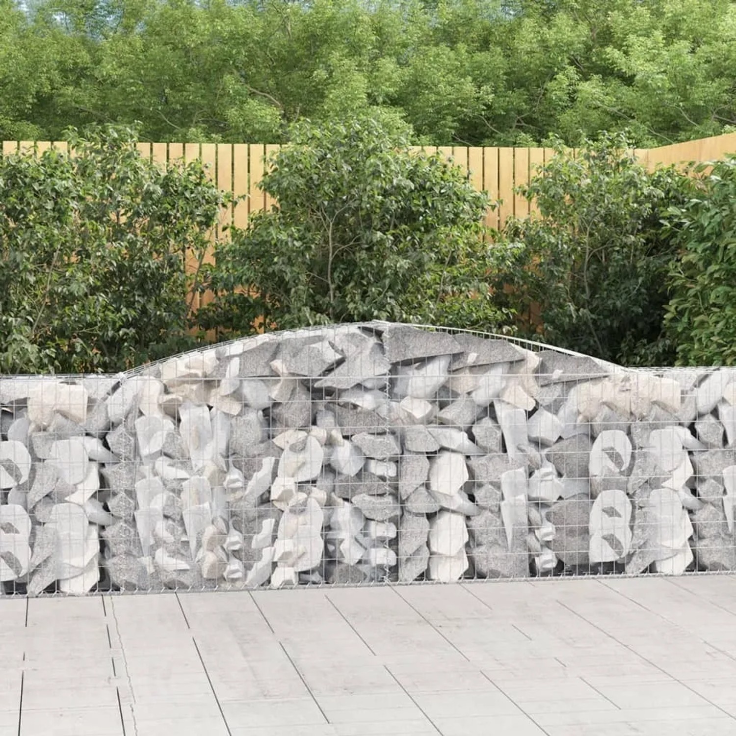 Gefüllte Gabione mit Hochbogen als dekoratives Element im Garten.