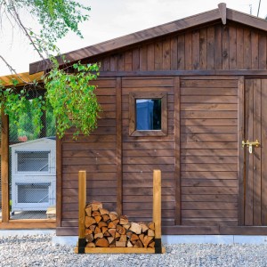 2er Set Relaxdays Holzstapelhilfe aus Stahl, schwarz pulverbeschichtet, vor Holzhütte mit Brennholz