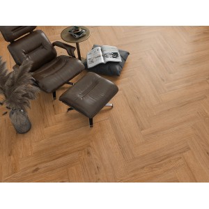 Verlegtes Classen Ville Laminat Codos Oak im Fischgrätmuster mit Sessel und Beistelltisch.