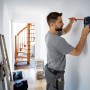 Handwerker nutzt Bosch Professional GMS 120-27 Ortungsgerät an Wand. Prüfwerkzeug zur Lokalisierung.
