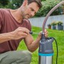 Mann montiert Gardena Tauch-Druckpumpe 5900/4 inox automatic im Garten.