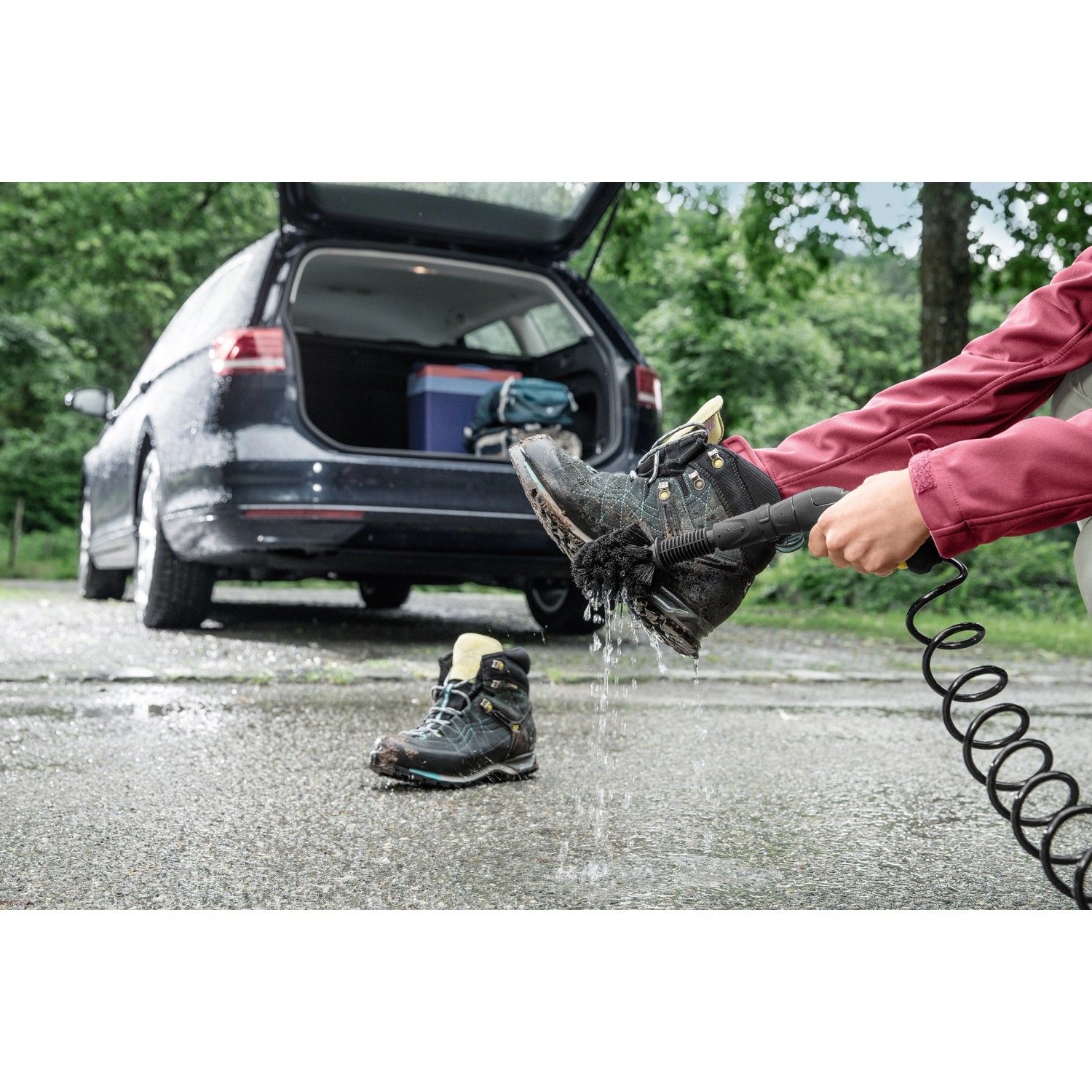 Kärcher Adventure Zubehörbox für OC 3: Reinigung von Wanderschuhen mit Universalbürste vor Auto.