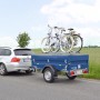 Stema Blue Man 750 Autoanhänger mit Fahrrädern auf dem Deckel, gezogen von einem PKW.