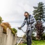 Mann mit 3M Peltor Gehörschutz X2A beim Rasentrimmen im Garten.