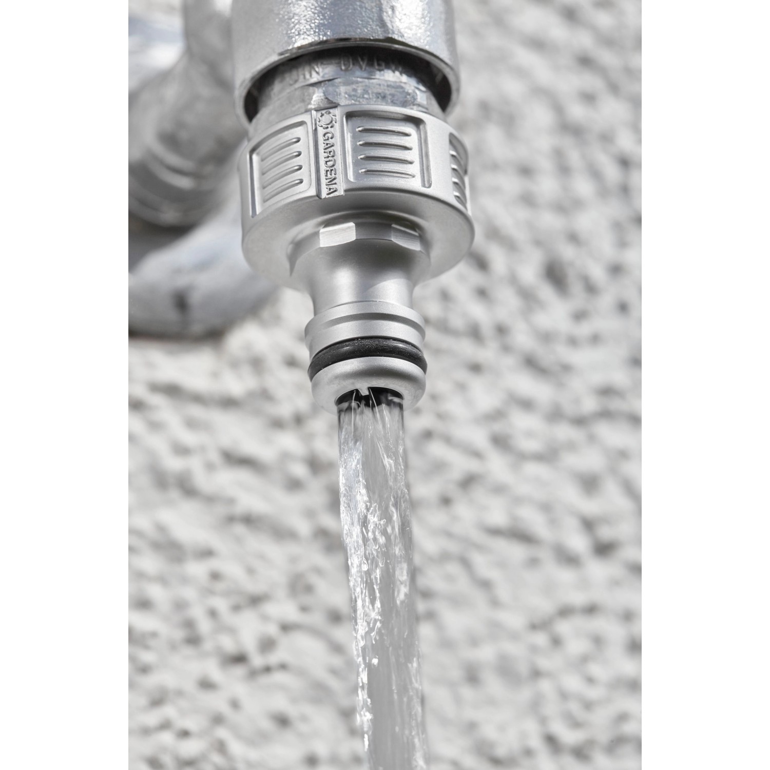 Gardena Premium Hahnverbinder (G 1'') am Wasserhahn mit laufendem Wasser.