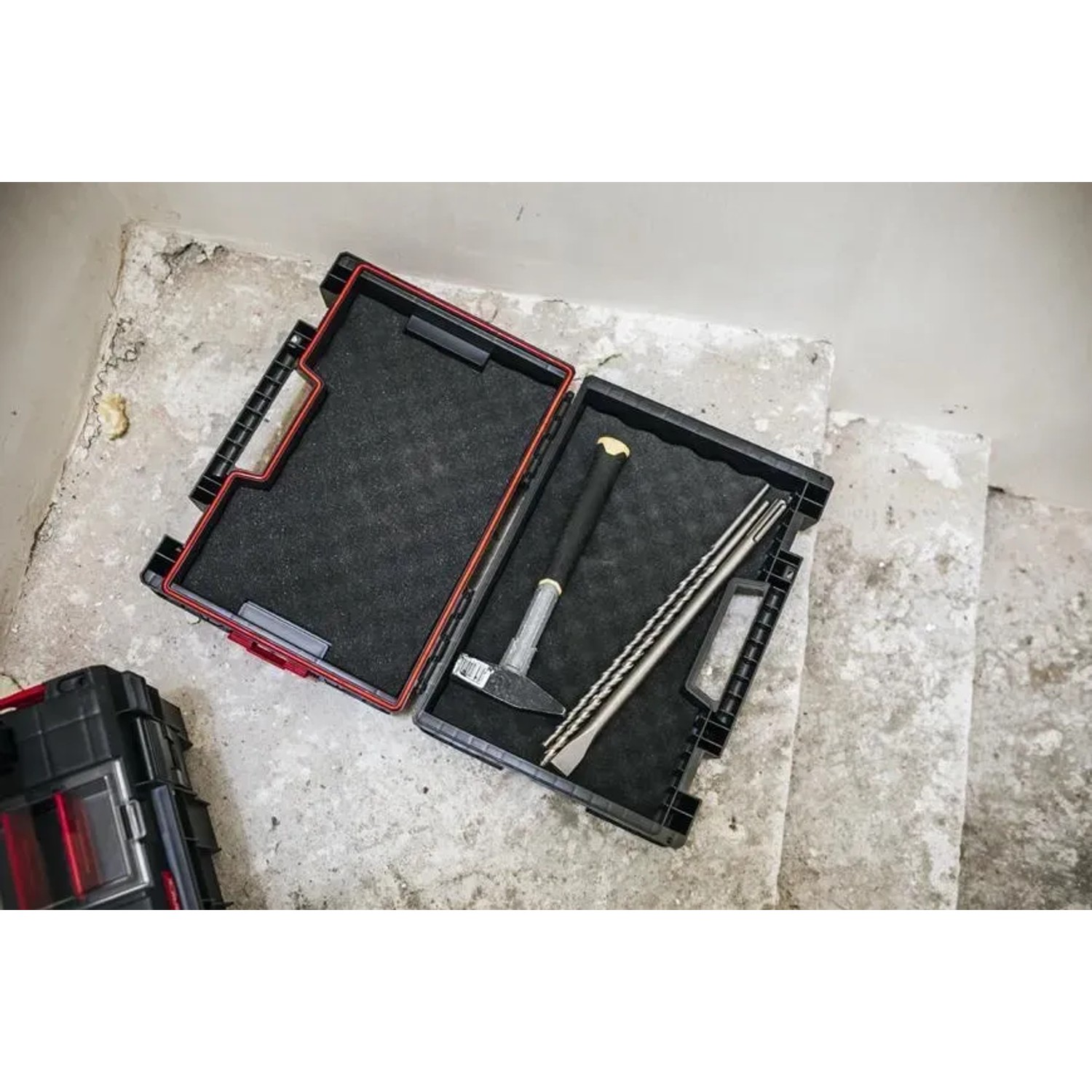 Offener, schwarzer PROREGAL QBRICK Werkzeugkasten mit Hammer und Meißel. Metallkoffer mit Tragegriff.