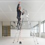 Mann auf Leiter mit Bosch Professional Linienlaser GCL 2-15, der rote Laserlinie an Decke projiziert.