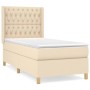 Cremefarbenes Boxspringbett (90x190 cm) mit Matratze und gestepptem Kopfteil.