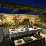 Terrasse mit Philips Outdoor-Wandleuchte Bustan und Bewegungssensor, beleuchteter Esstisch.