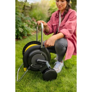 Kärcher Schlauchwagen HT 2.20 Set mit 20m Schlauch, bedient von einer Person im Garten.