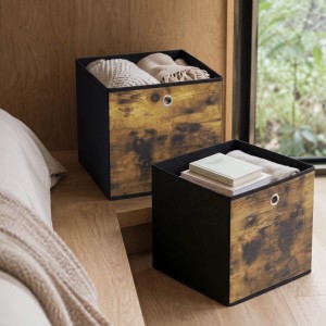 Zwei braun-schwarze Sekey Stoffboxen mit Holzoptik und Metallöse, gefüllt mit Kleidung und Büchern, auf Holzregal.