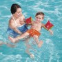 Kind mit Bestway Früchte-Schwimmflügeln im Wasser, unterstützt von einer Frau. Wassermelonen Design.