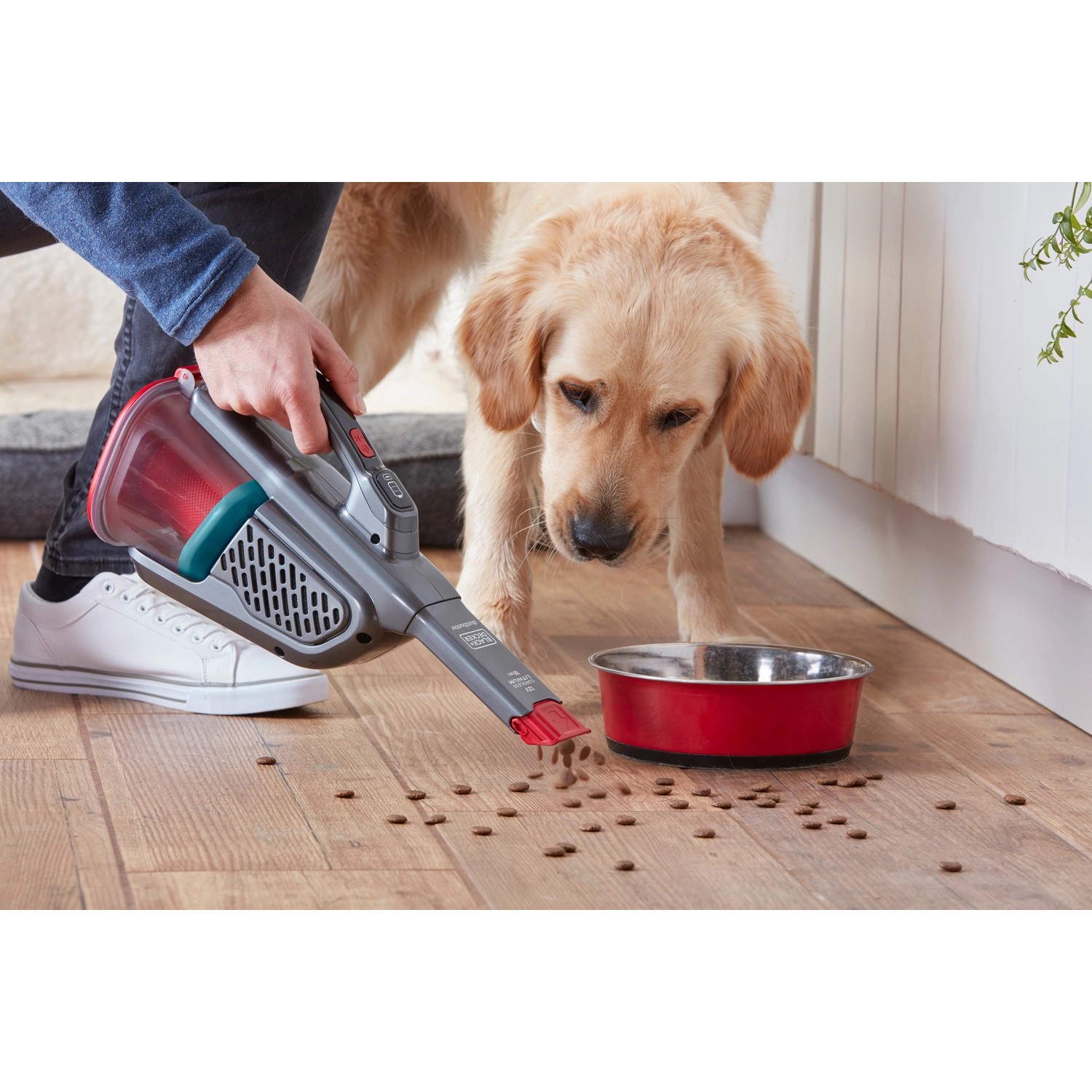 Black+Decker Akku-Handstaubsauger BHHV315B im Einsatz neben Hundenapf zum Aufsaugen von Futterresten.