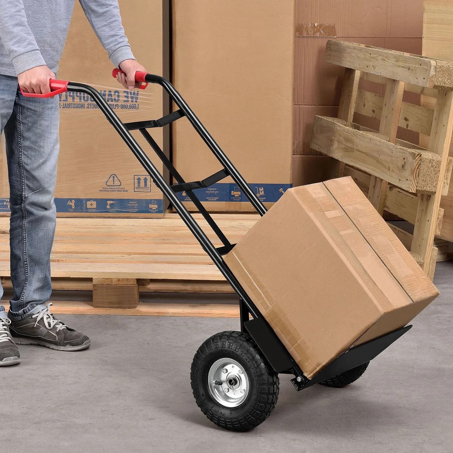 Schwarze Juskys Sackkarre mit Karton, roten Griffen und klappbarer Schaufel für bis zu 100 kg.