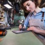 Frau graviert mit Worx MakerX Akku-Multitool ein Werkstück. Inkl. Zubehör.