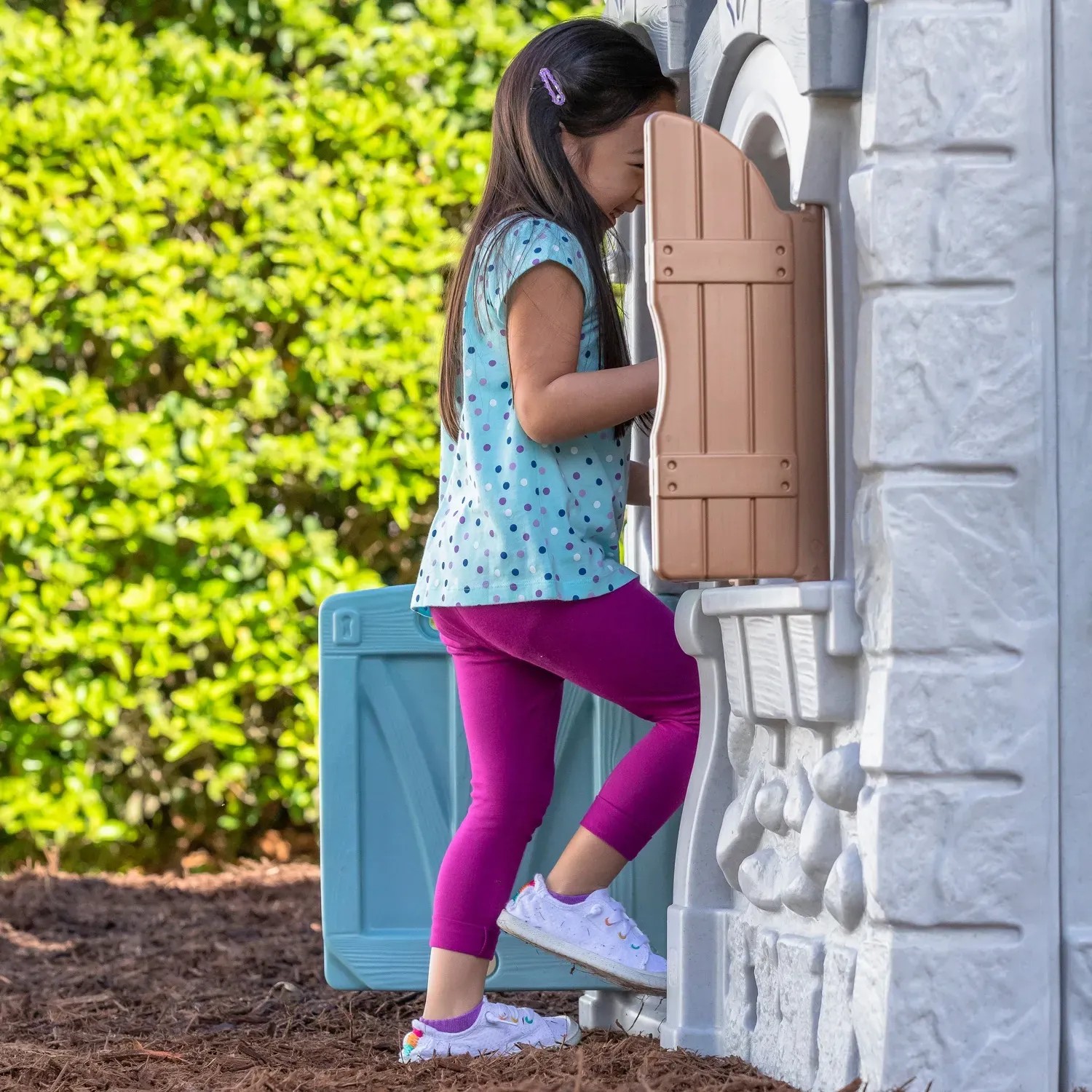 Mädchen klettert auf Step2 Spielhaus Adventures mit Rutsche, 2-Etagen, für fantasievollen Spielspaß.